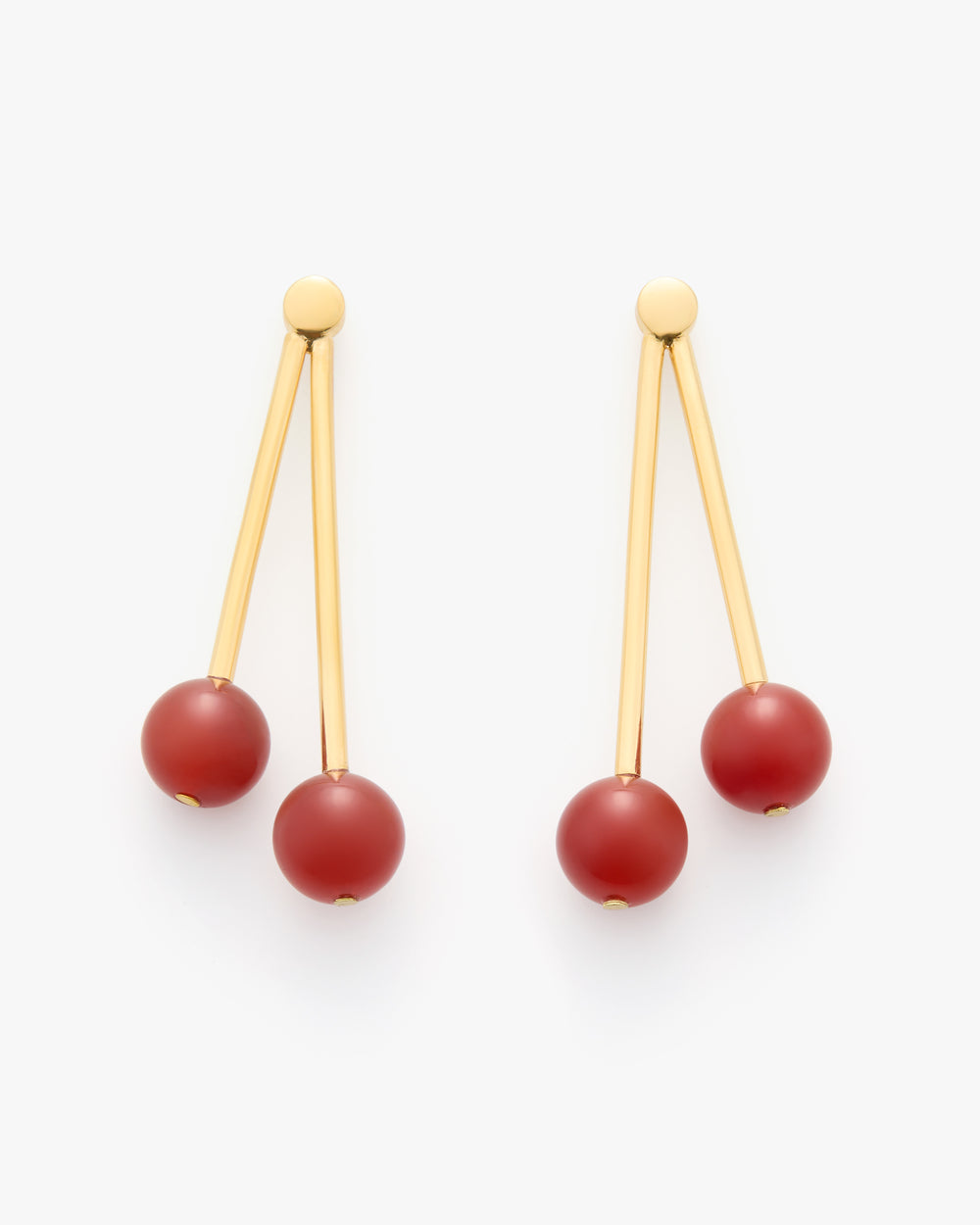 Earrings with long gold bars and round red beads at the ends.