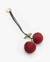 Cherry-shaped woven keychain with two leaves attached.