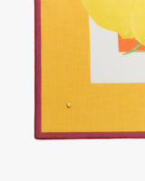 Corner of a colorful patterned textile with a small pin attached.