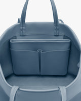 Open travel bag with interior compartments and handles visible.