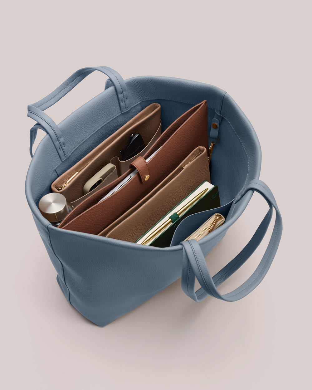 Open tote bag with organized compartments and assorted items.