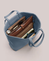 Open tote bag with organized compartments and assorted items.