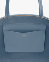 Close-up of a bag's pocket with brand logo visible.