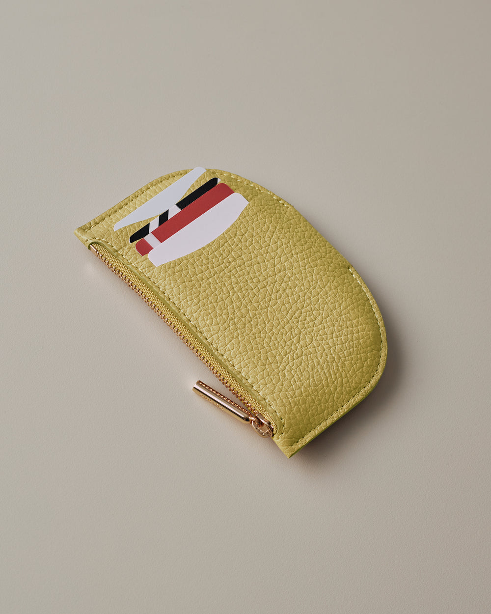 Cardholder with zipper and three cards partially visible in slots.