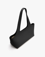 Rectangular handbag with long handles on plain background.