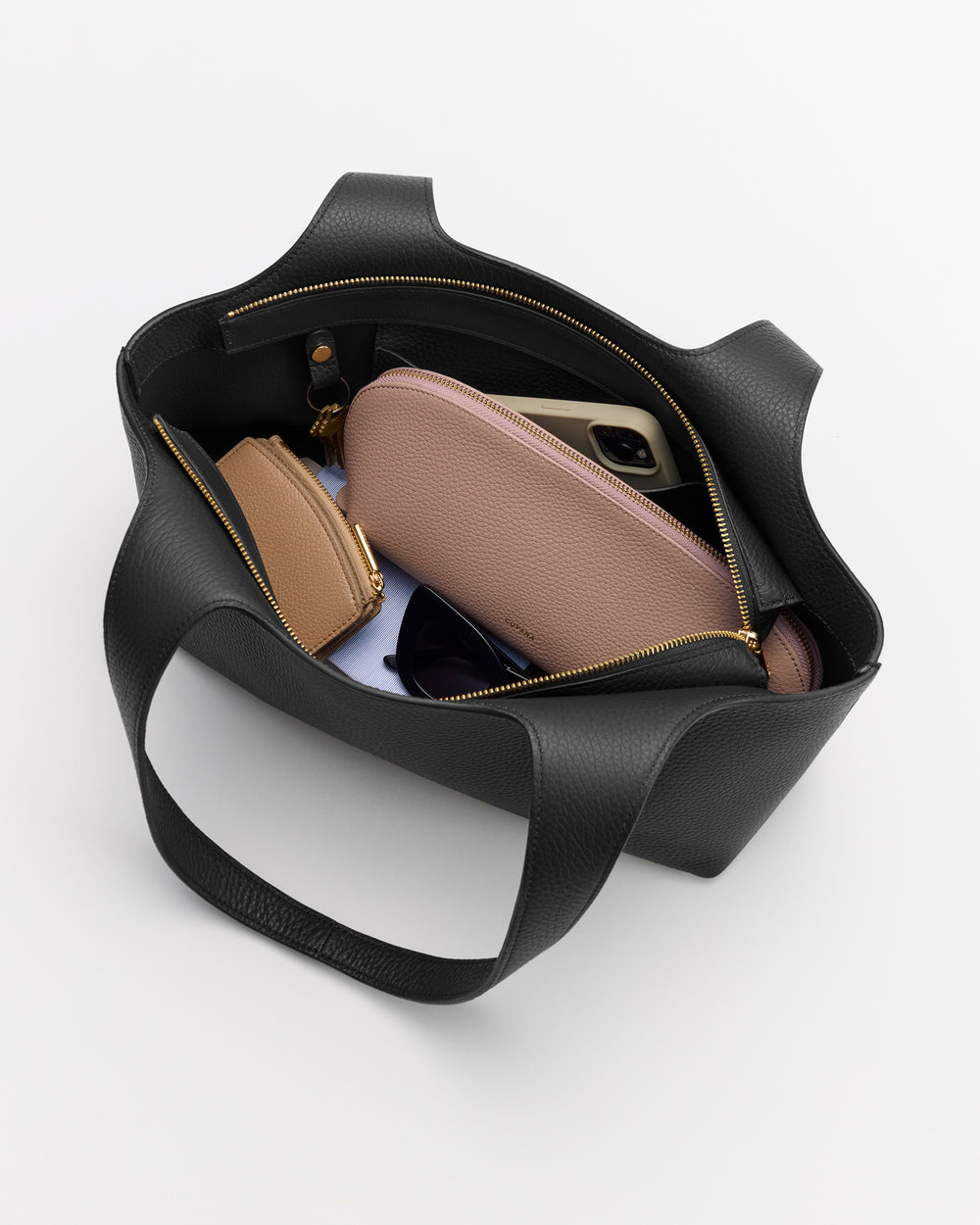 Open tote bag with wallets, glasses, and a phone inside.