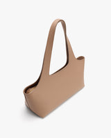 A sleek, minimalist handbag with a long shoulder strap.