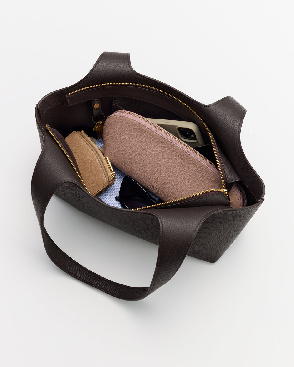 Open tote bag with small bags, sunglasses, and a phone inside.