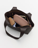 Open tote bag with small bags, sunglasses, and a phone inside.