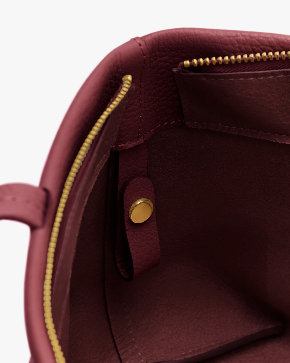 Open handbag with gold zipper and small interior pocket.