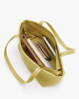 Open handbag with compartments holding a wallet, notebook, and pen