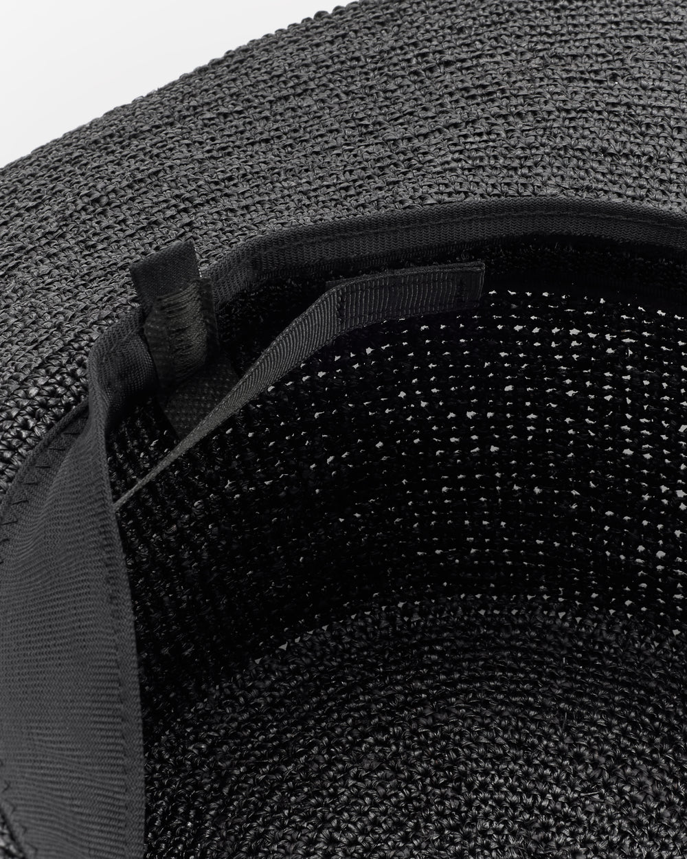 Wide-brimmed woven hat with inner strap detail.