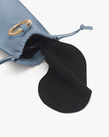 Small drawstring pouch with an open flap and gold metal accent.