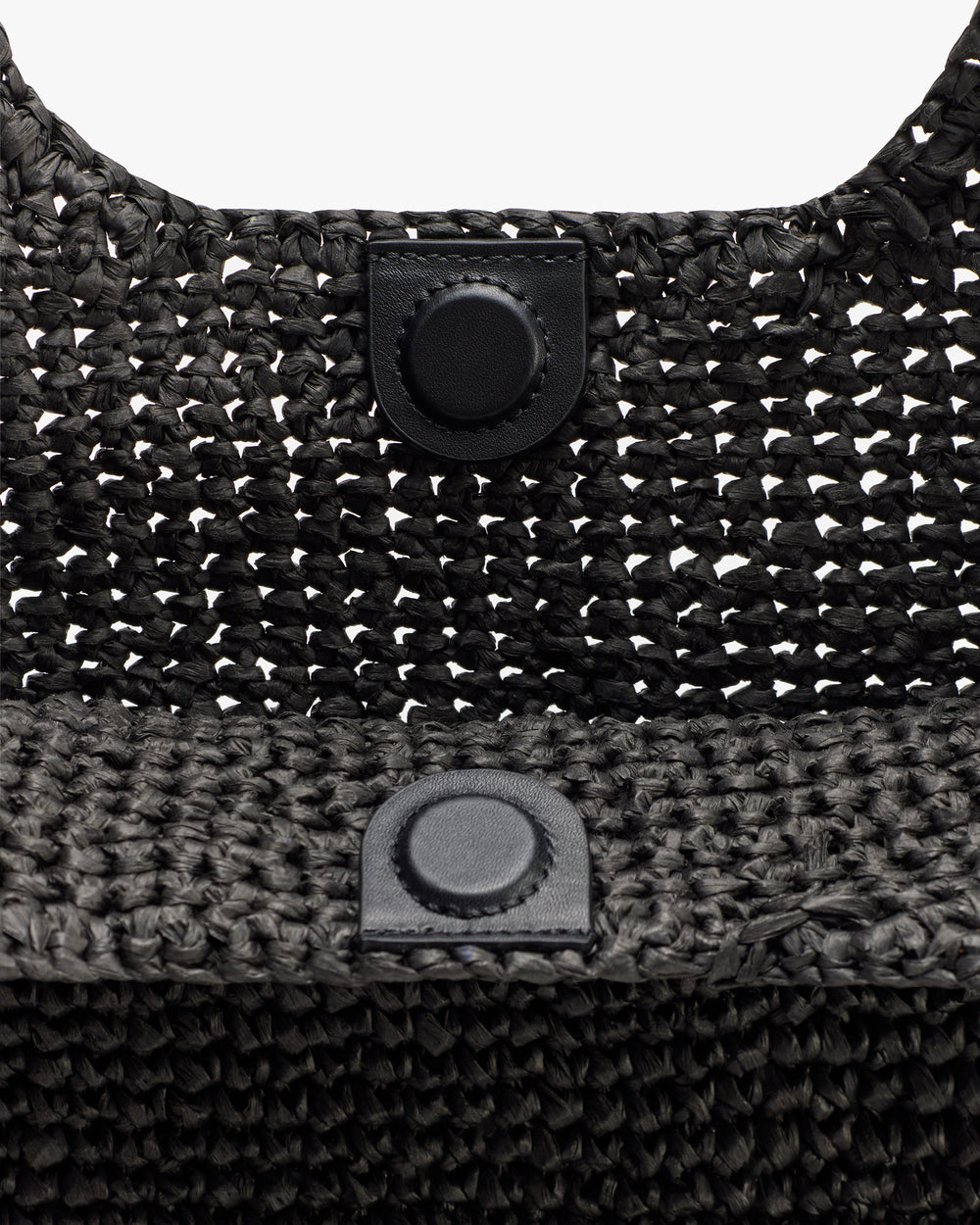 Close-up of woven bag with button clasp.