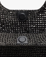 Close-up of woven bag with button clasp.