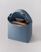 Open handbag with sunglasses and pouches inside.