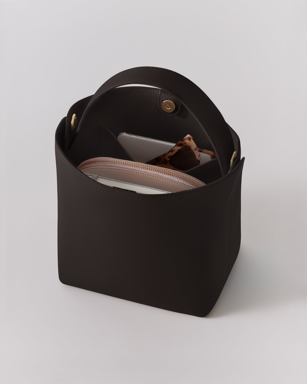 Open handbag with smartphone, eyeglasses, and pouch inside