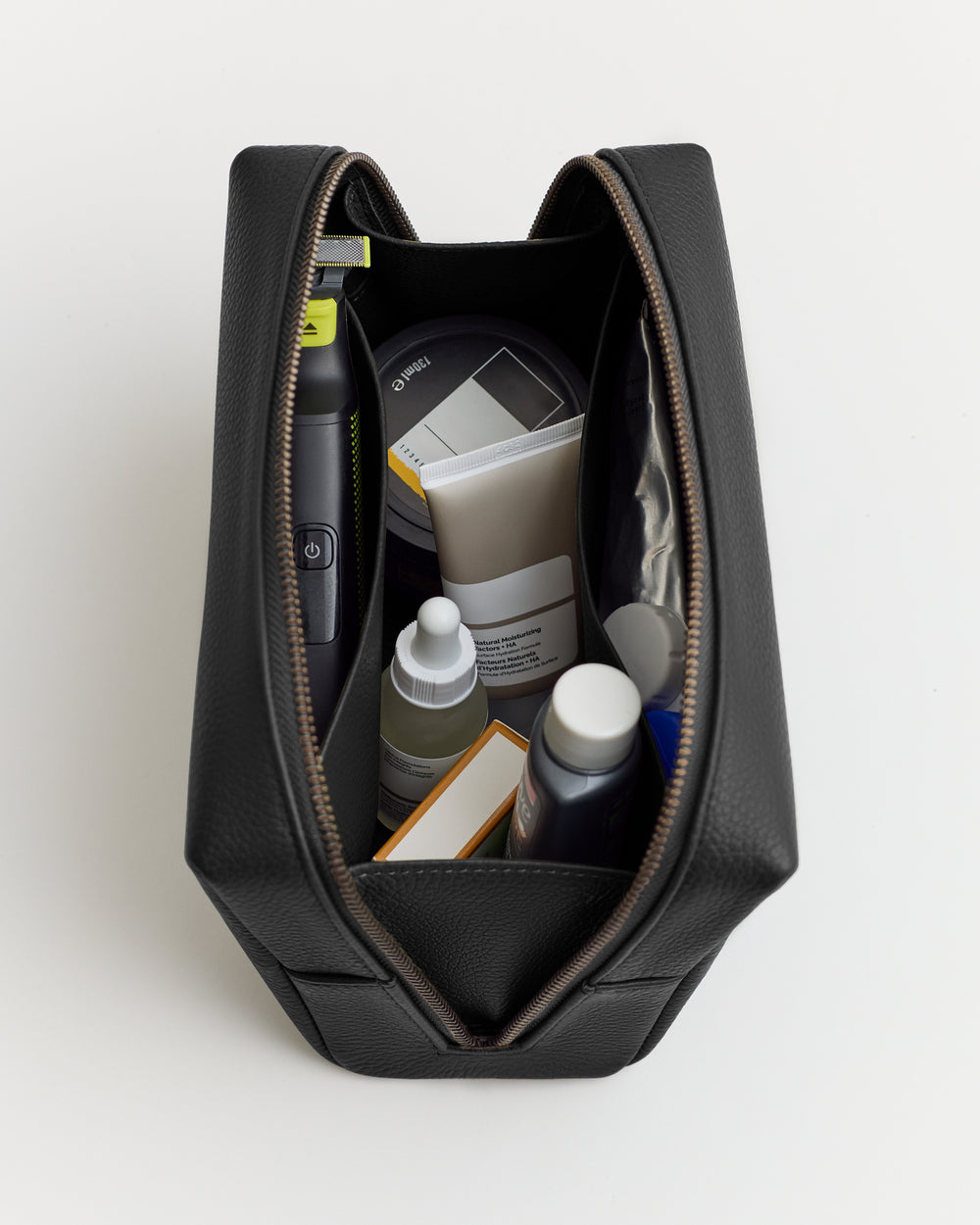 A toiletry bag opened to show various grooming products inside.