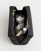 A toiletry bag opened to show various grooming products inside.