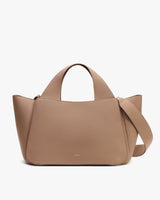 Handbag with wide top handles and shoulder strap shown.