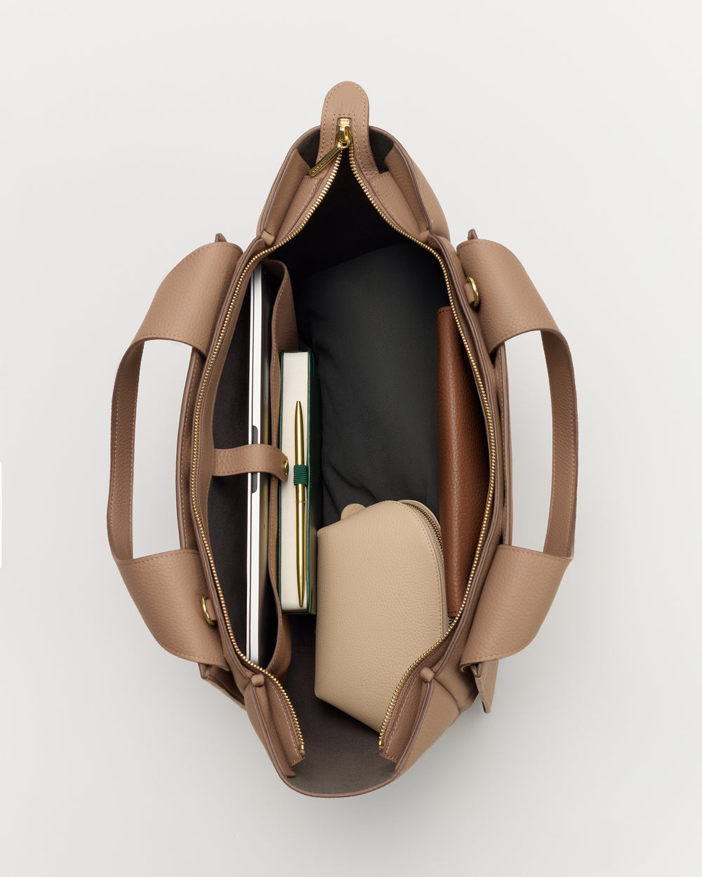 Open handbag with books, a wallet, and a pouch inside.