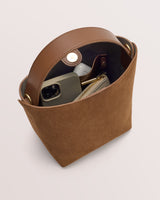 Open handbag with phone, earbuds, and wallet inside