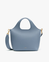 A handbag with a round handle and a shoulder strap.