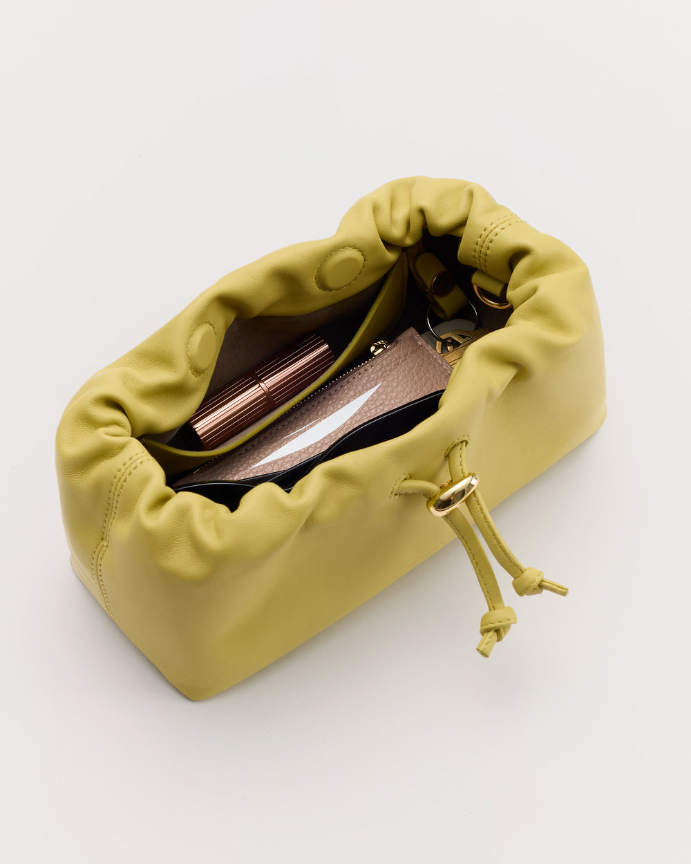 Open drawstring bag with cosmetics inside.