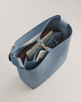 Open handbag with compartments holding various items.