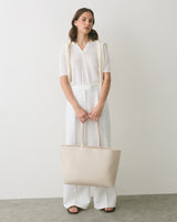 Person standing with a shoulder bag and hands in front