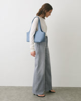 Person in wide-leg jeans with bag on shoulder facing sideways