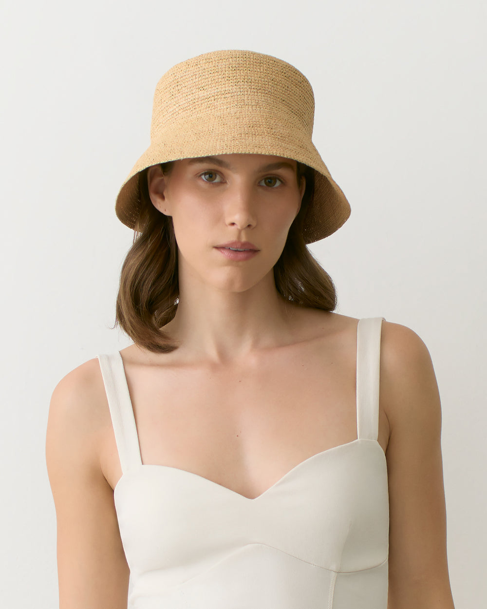 Person wearing a straw hat and a sleeveless top facing forward
