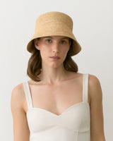 Person wearing a straw hat and a sleeveless top facing forward