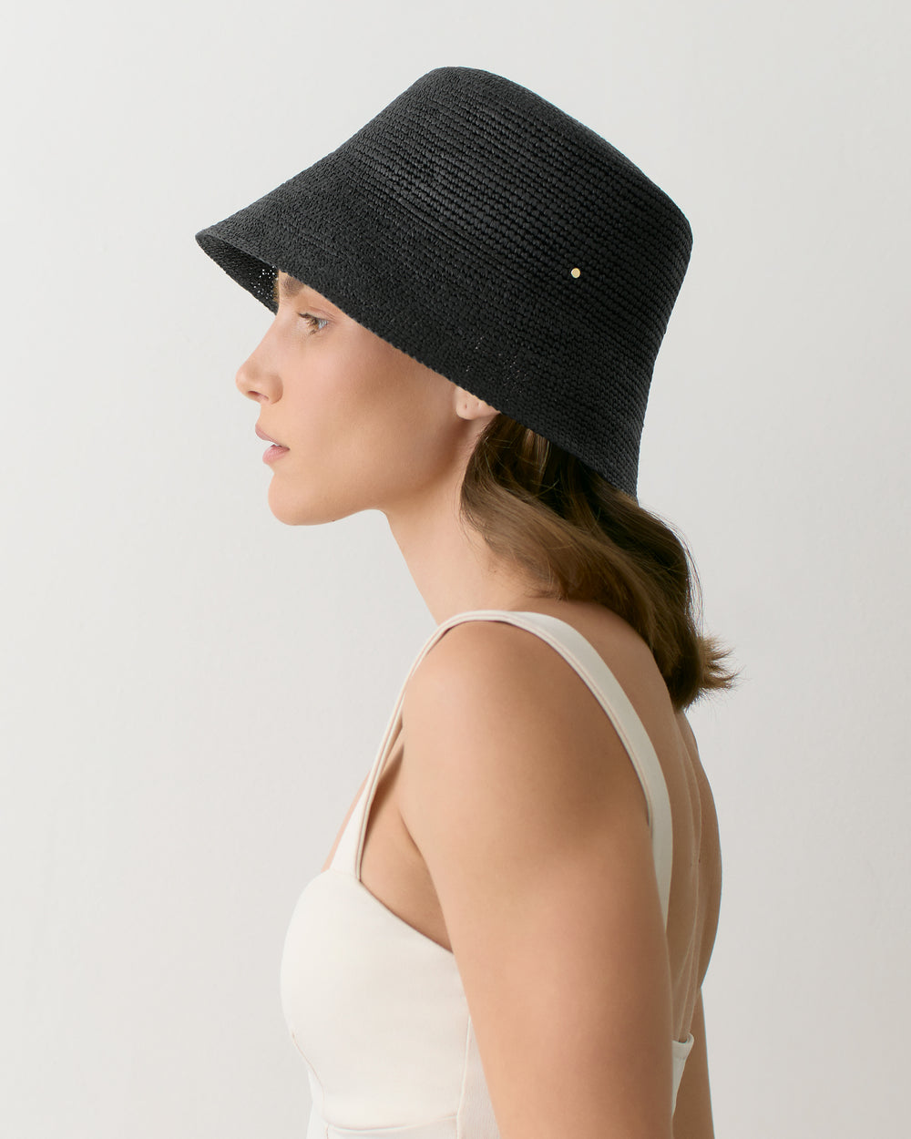 Person wearing a hat and sleeveless top side view