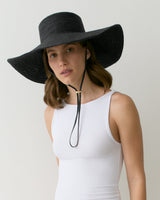 Person wearing wide-brimmed hat and sleeveless top.
