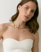 Person wearing jewelry and strapless top, facing camera.