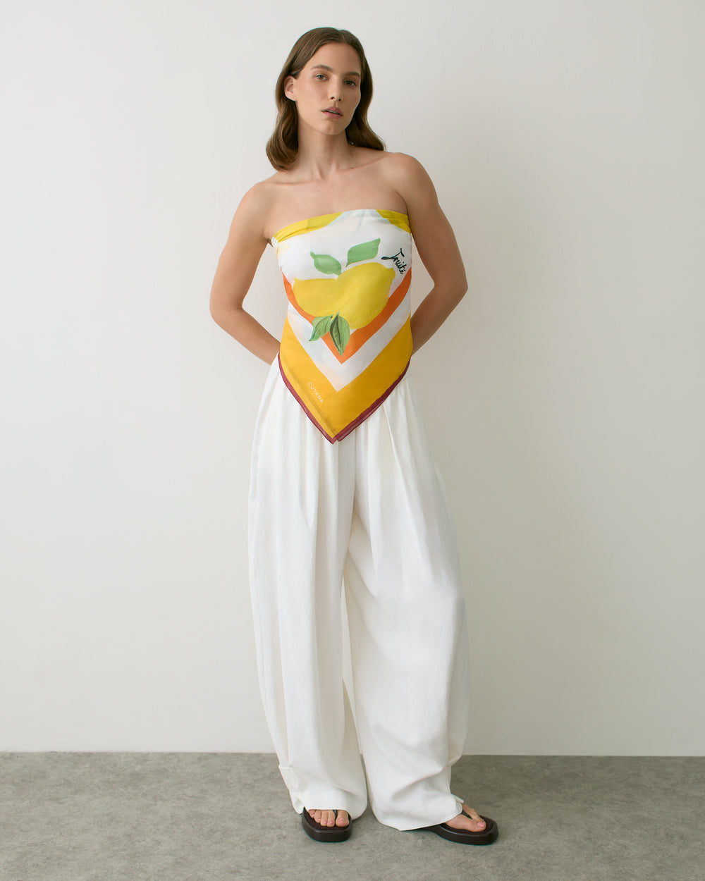 Woman wearing a bandana scarf top with fruit design and wide-leg pants