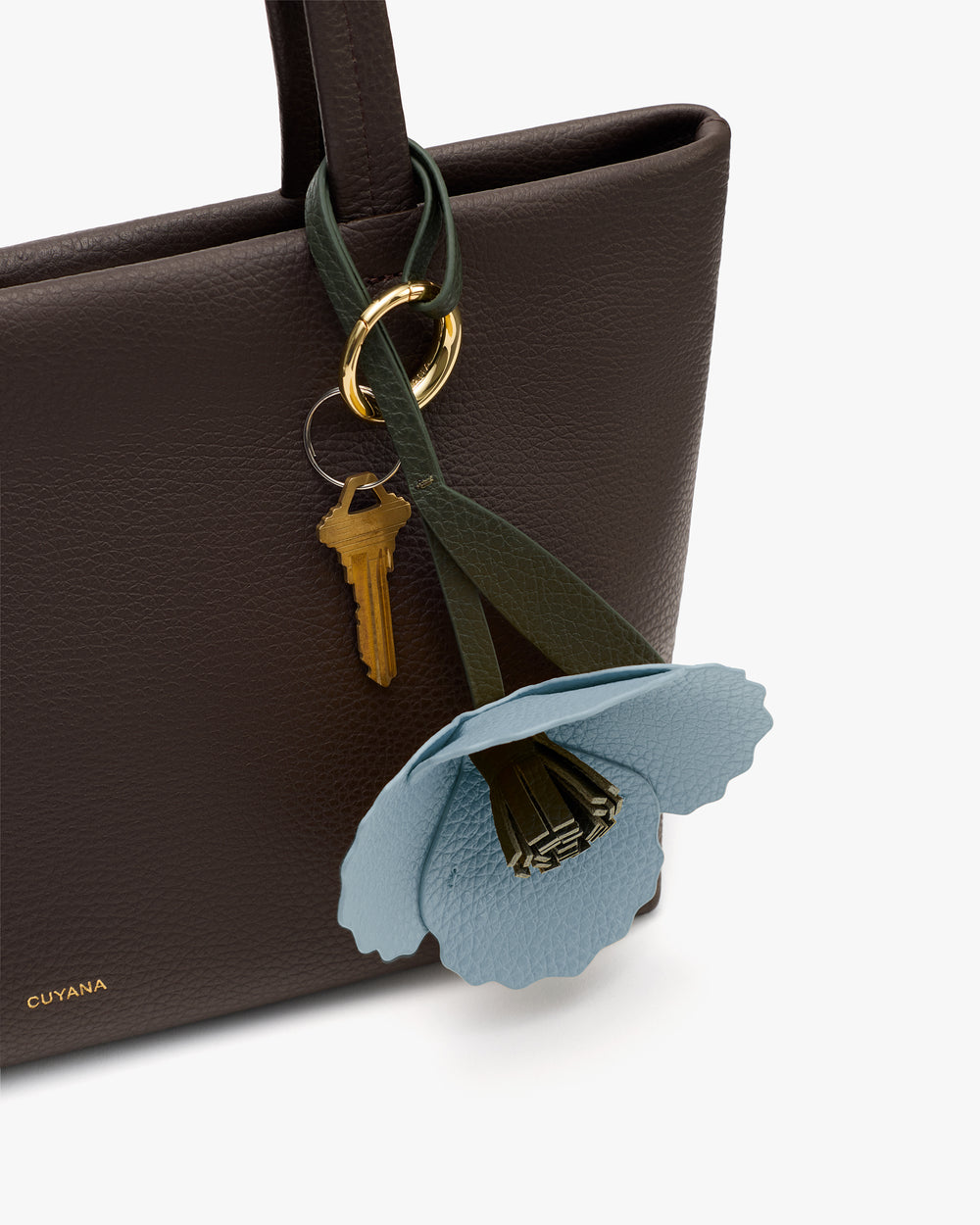 Handbag with decorative flower and keychain attached.