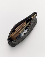 Woven clutch bag with zipper partially open, showing purse and sunglasses inside.