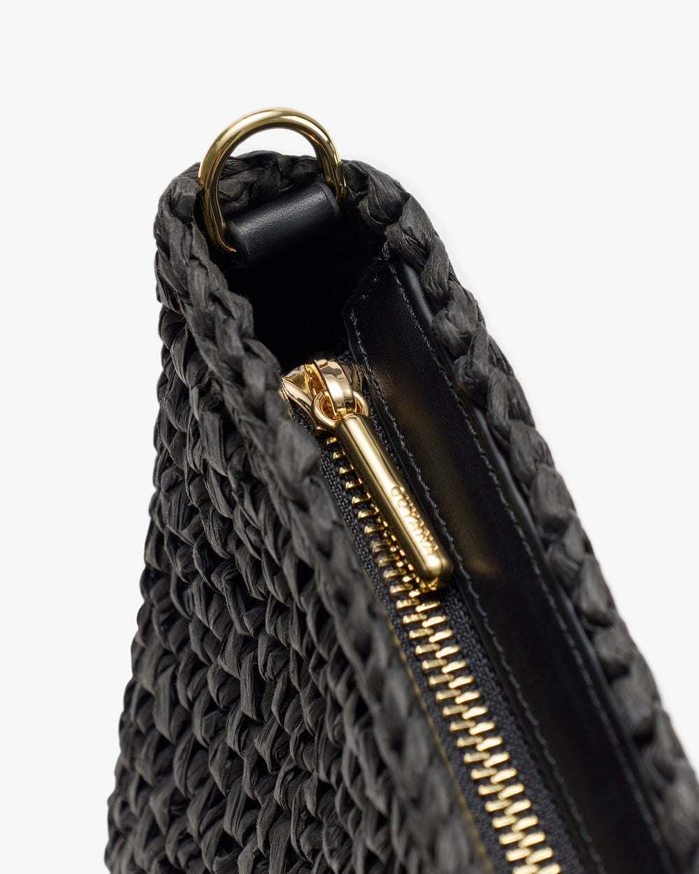 Woven bag close-up with zipper and metal ring detail.
