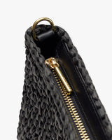 Woven bag close-up with zipper and metal ring detail.