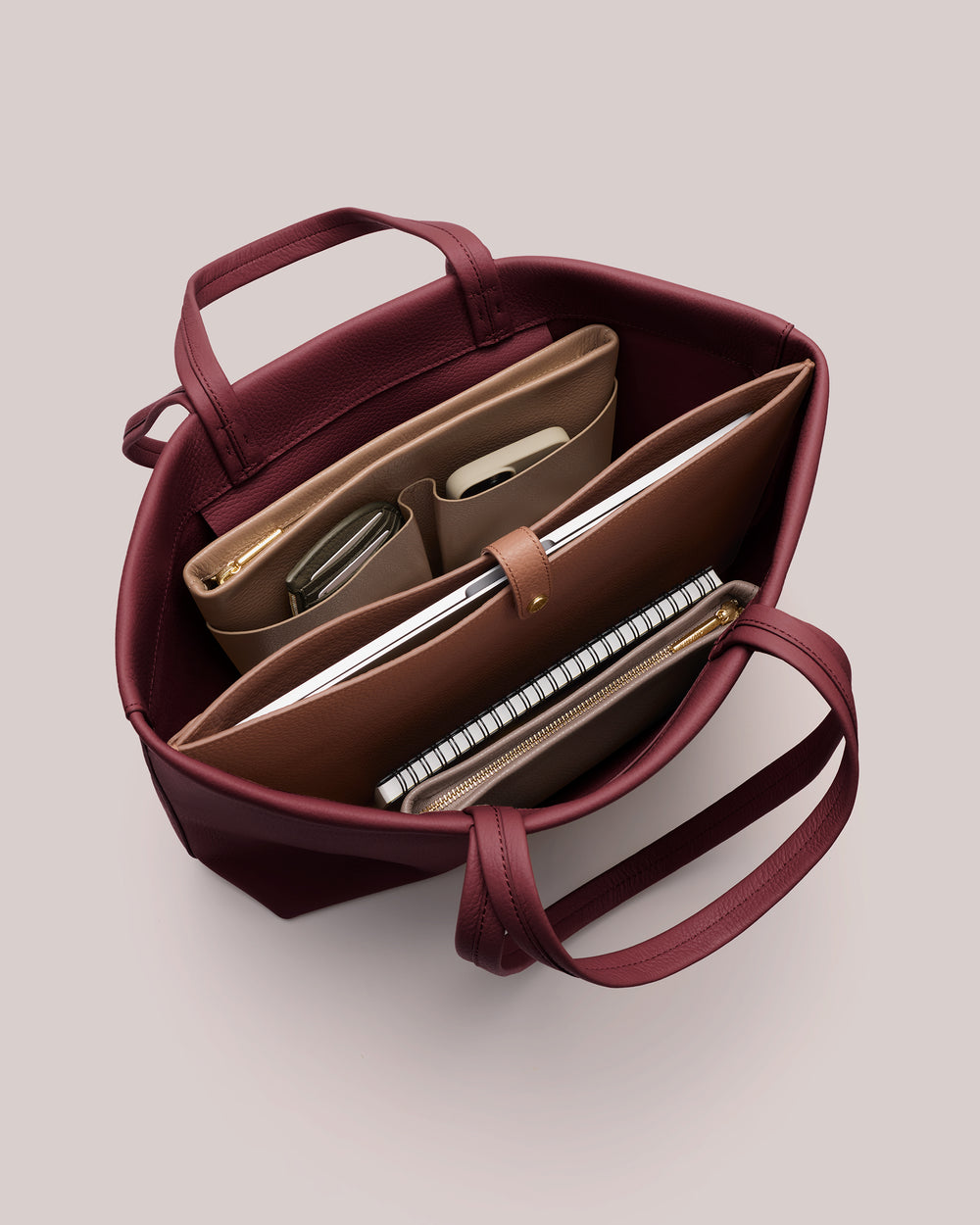 Open handbag with organized pockets and items inside.