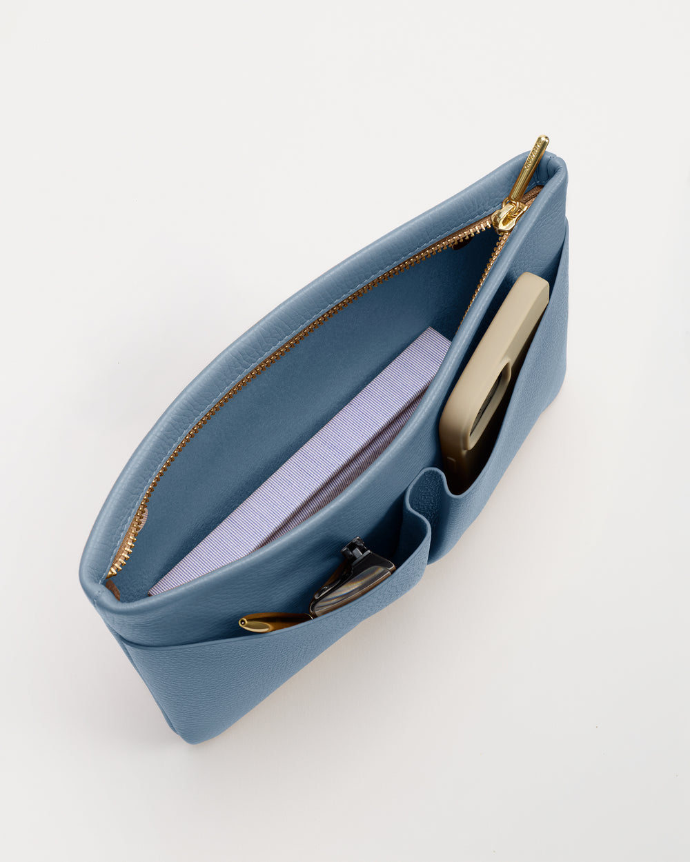 Open bag with a notebook, phone, and pen inside.