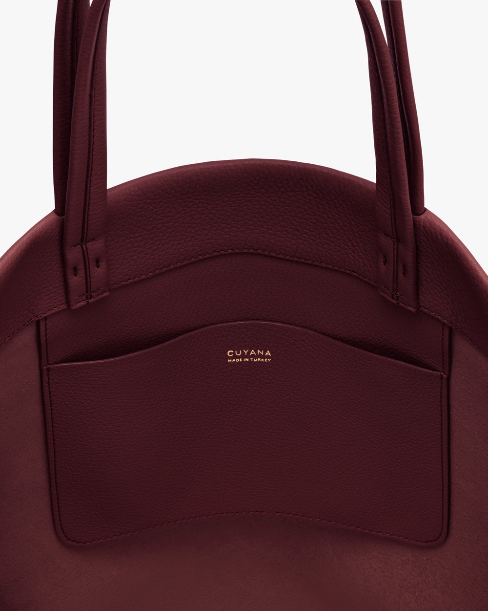 Close-up of a round handbag with a pocket and two handles.