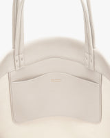 Close-up of a tote bag with a large front pocket and two handles.