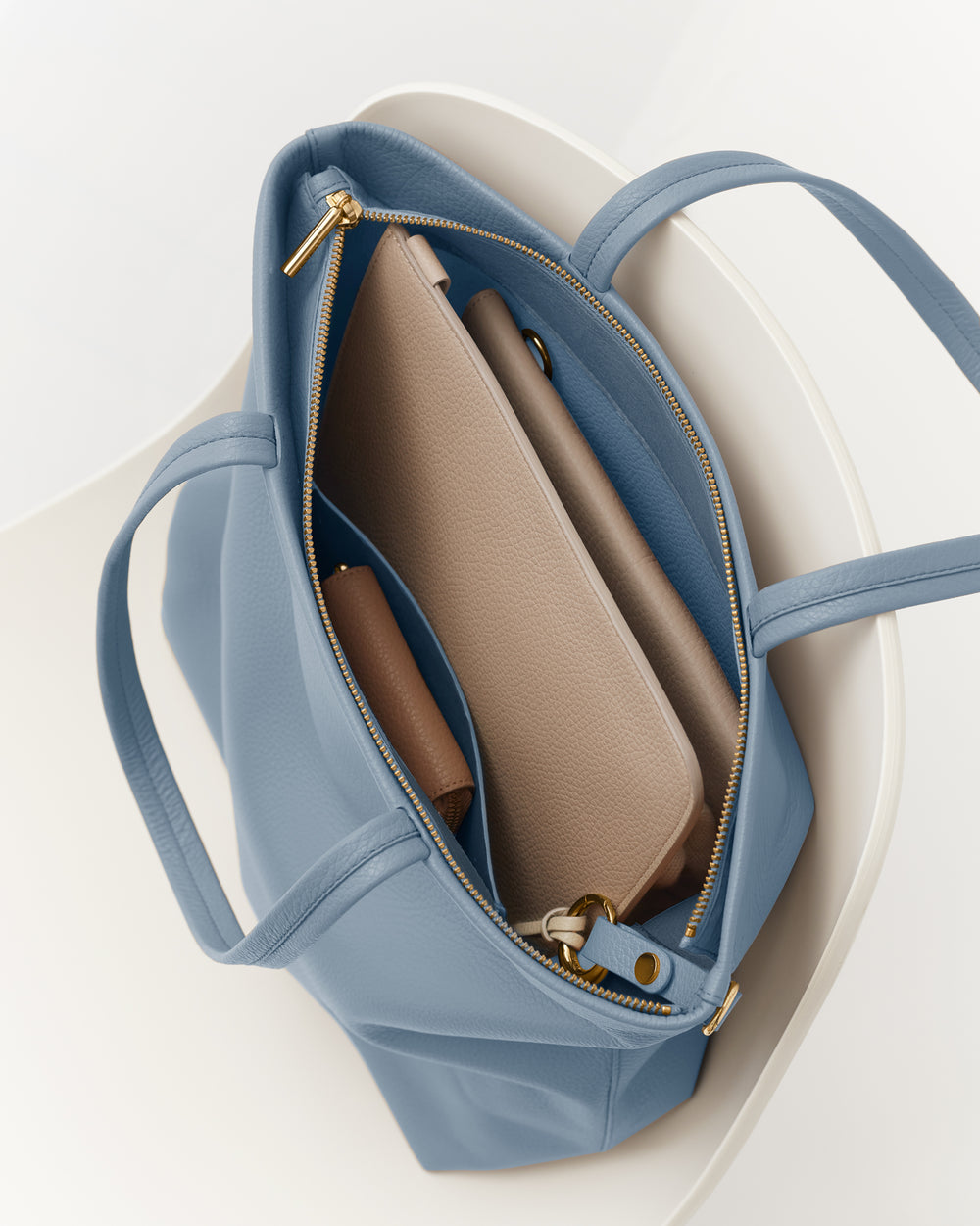 Open travel bag with a wallet and zippered compartment inside.