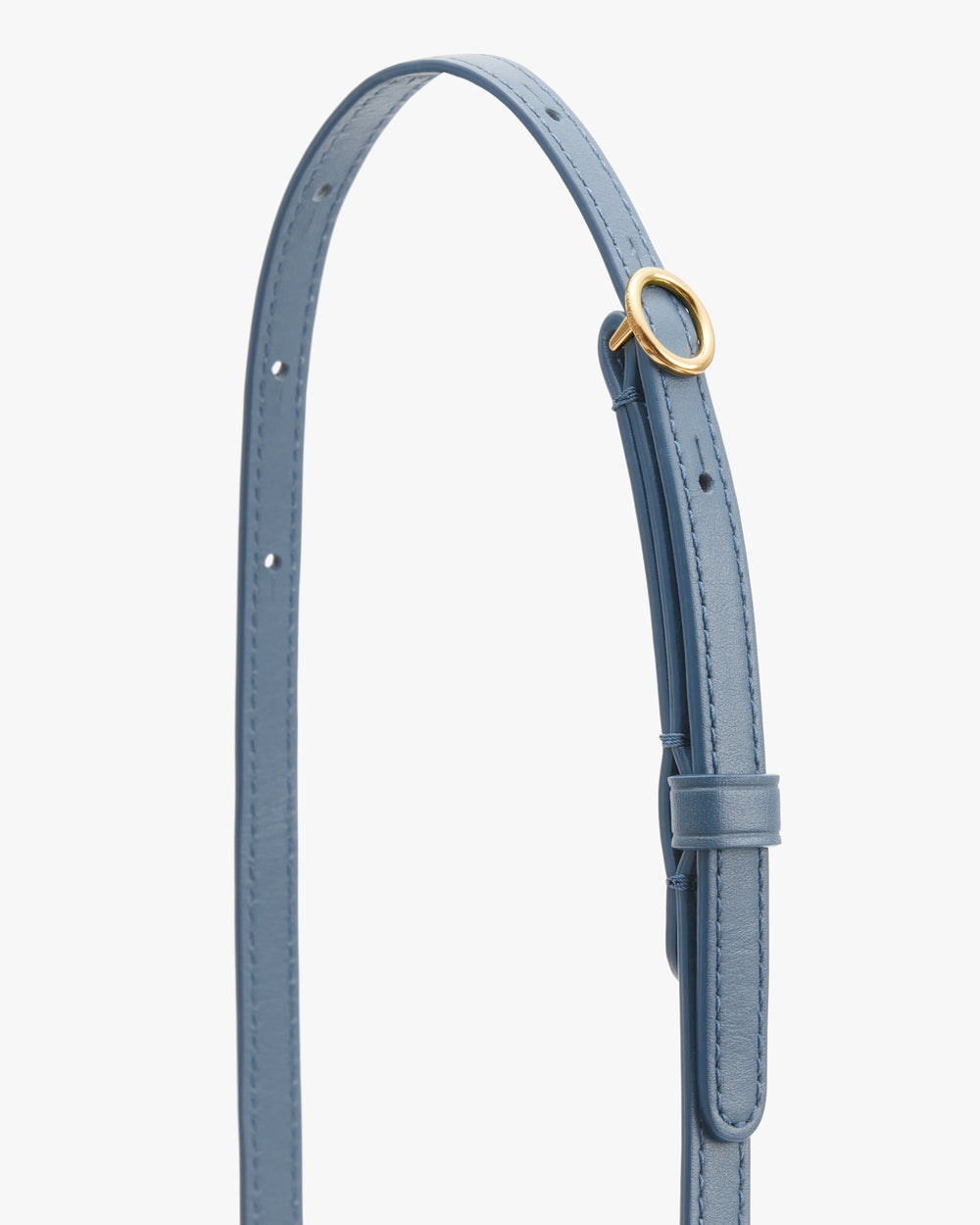 Close-up of a belt with a circular buckle and adjustable holes.