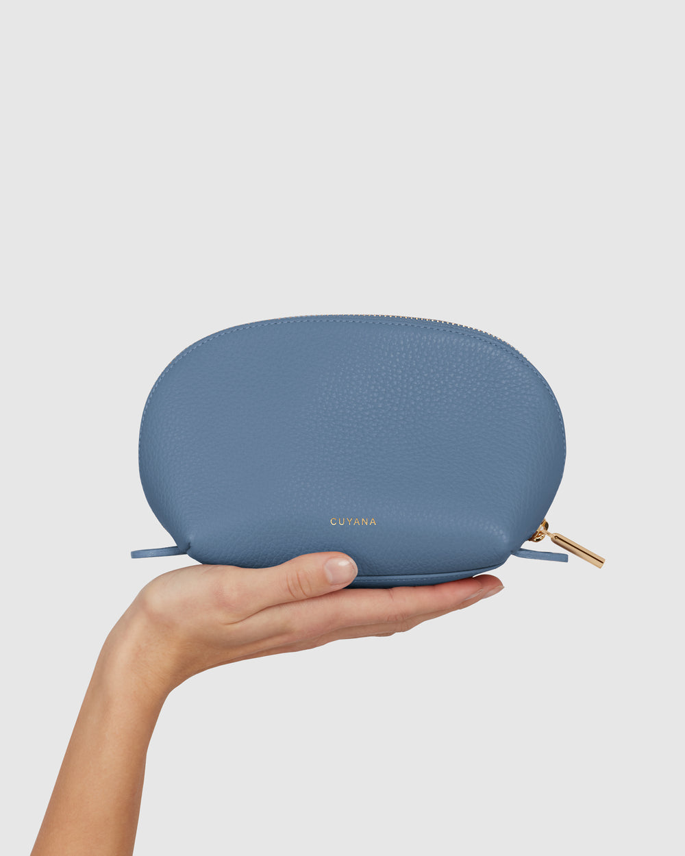 Hand holding a small zippered pouch vertically.