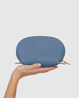 Hand holding a small zippered pouch vertically.