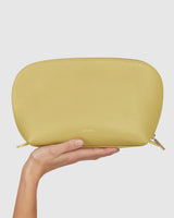 Hand holding a zippered pouch toward the camera.